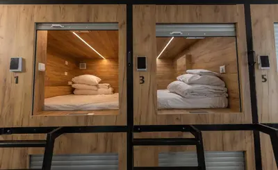 two mirrors in a room with two beds at Expo capsule Hostel in Prague
