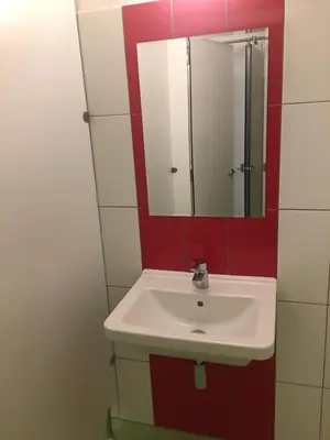 a bathroom with a white sink and a mirror at Expo capsule Hostel in Prague
