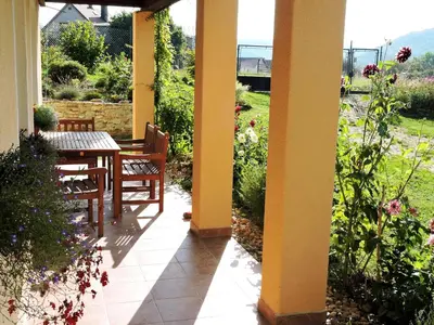 a porch with a table and chairs and flowers at Apartment Boroví in Karlštejn