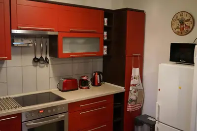 a kitchen with red cabinets and a white refrigerator at Apartment Boroví in Karlštejn