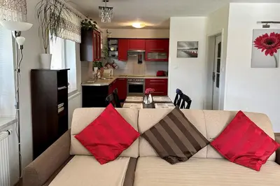 a living room with a couch with red pillows on it at Apartment Boroví in Karlštejn