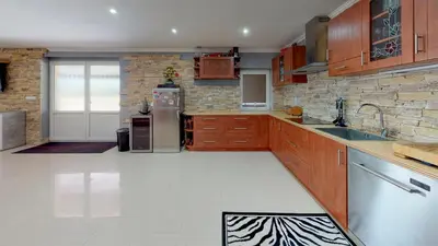 a large kitchen with wooden cabinets and a zebra print floor at Vehlovice Apartments in Mělník