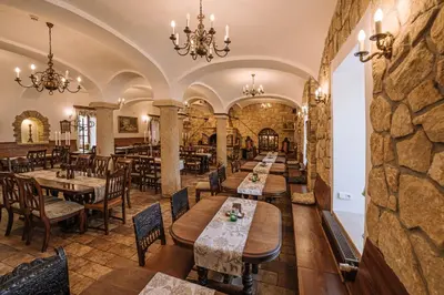 a restaurant with tables and chairs and a stone wall at Hotel Svatojánský Dvůr in Prague