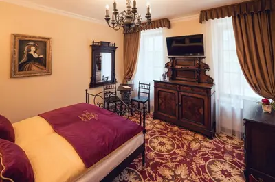 a bedroom with a bed and a television in it at Hotel Svatojánský Dvůr in Prague