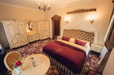 a bedroom with a large bed and a table at Hotel Svatojánský Dvůr in Prague