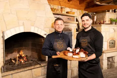 two men holding a tray of food in front of an oven at Hotel Svatojánský Dvůr in Prague