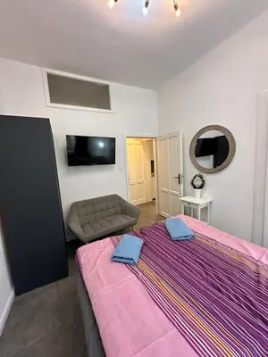a bedroom with a large bed with a purple blanket at Karlin Oasis 2-Bedroom Apartment in Prague