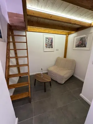 a room with a ladder and a couch and a chair at Karlin Oasis 2-Bedroom Apartment in Prague