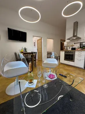 a living room with a glass table and chairs at Karlin Oasis 2-Bedroom Apartment in Prague