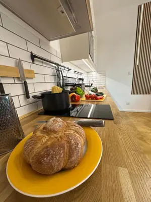 a loaf of bread on a yellow plate in a kitchen at Karlin Oasis 2-Bedroom Apartment in Prague