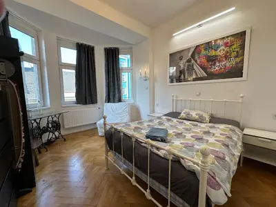 a bedroom with a bed in a room with windows at Karlin Oasis 2-Bedroom Apartment in Prague