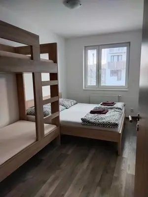 a bedroom with two bunk beds and a window at Apartmán Karolína in Poděbrady