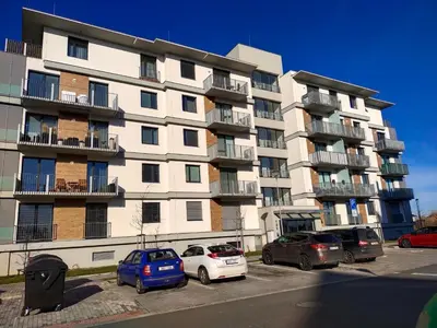 a large apartment building with cars parked in a parking lot at Apartmán Karolína in Poděbrady