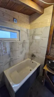 a bathroom with a white tub in a room at Old Summer House with renovated bathroom in Prague