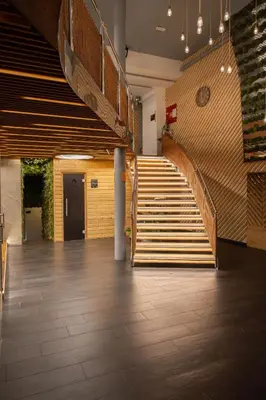 a staircase in a large room with wooden floors and stairs at Wellness Hostel Central in Prague