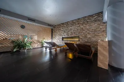 a living room with chairs and a brick wall at Wellness Hostel Central in Prague