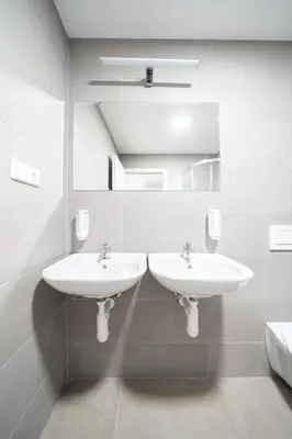 a bathroom with two sinks and a mirror at Wellness Hostel Central in Prague