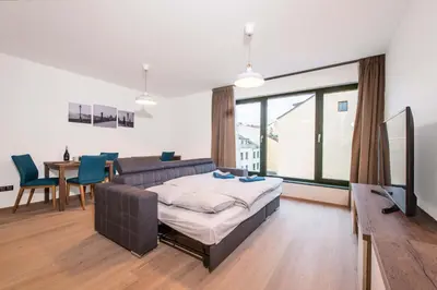 a bedroom with a bed and a table and chairs at Quiet & new apartment near city center with garage in Prague