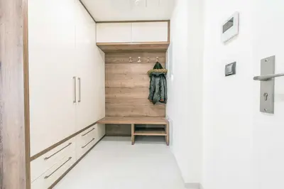 a walk in closet with white cabinets and a wooden wall at Quiet & new apartment near city center with garage in Prague