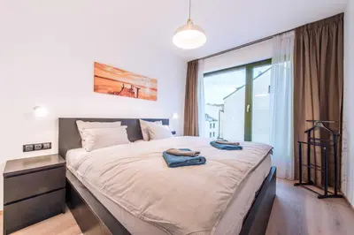 a bedroom with a large bed with two towels on it at Quiet & new apartment near city center with garage in Prague