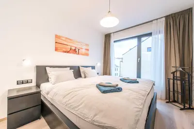 a bedroom with a large bed with two towels on it at Quiet & new apartment near city center with garage in Prague