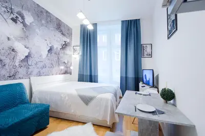 a bedroom with a bed and a blue couch at Modern apartment Pricna 4 in Prague