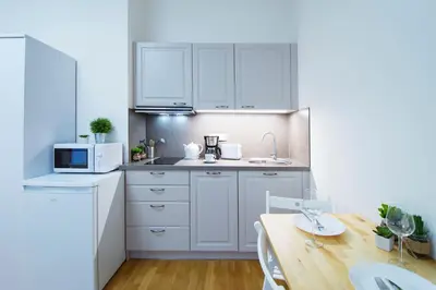 a kitchen with white cabinets and a wooden table at Modern apartment Pricna 4 in Prague