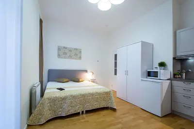 a white bedroom with a bed and a microwave at Modern apartment Pricna 4 in Prague