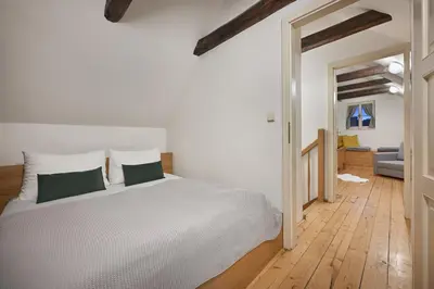 a bedroom with a white bed with green pillows at White Swan Boutique Apartments in Prague