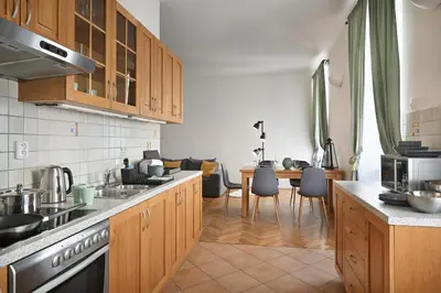 a kitchen with wooden cabinets and a dining room at White Swan Boutique Apartments in Prague