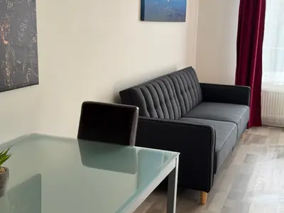 a living room with a couch and a glass table at Spacious 2BR with balcony in Prague - Comfort & Style in Prague