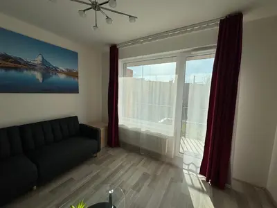 a living room with a couch and a large window at Spacious 2BR with balcony in Prague - Comfort & Style in Prague
