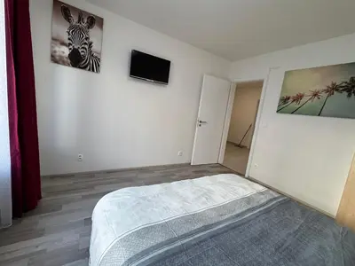 a bedroom with a bed and a tv on the wall at Spacious 2BR with balcony in Prague - Comfort & Style in Prague