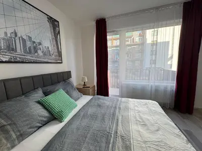 a bedroom with a bed with a green pillow on it at Spacious 2BR with balcony in Prague - Comfort & Style in Prague
