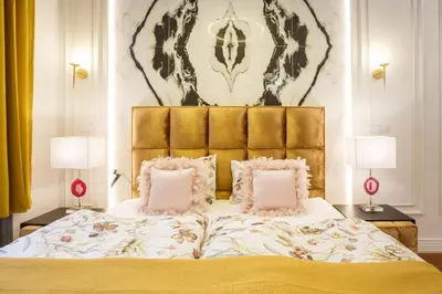 a bedroom with a large bed with two lamps at Palace Apartment by Main Station - President in Prague