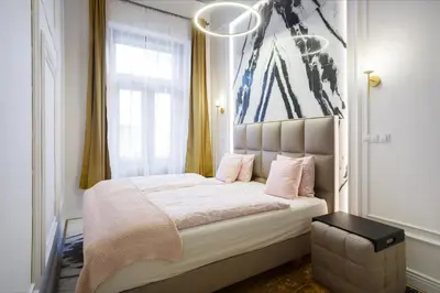 a bedroom with a large bed with pink pillows at Palace Apartment by Main Station - Premier in Prague