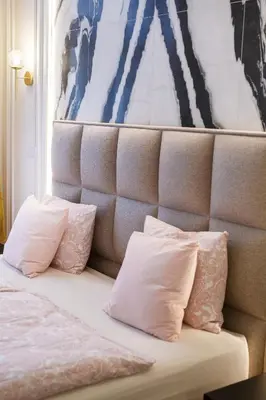 a bed with two pillows and a painting on the wall at Palace Apartment by Main Station - Premier in Prague