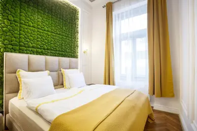 a bedroom with a large bed with a green wall at Palace Apartment by Main Station - Premier in Prague