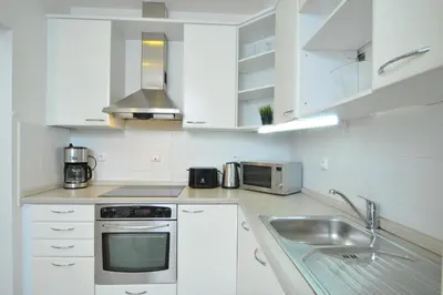 a white kitchen with a sink and a microwave at Selinor Old Town Apartments in Prague