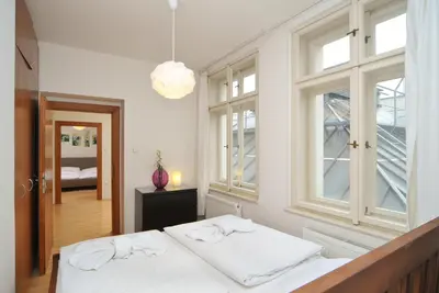a white bedroom with a bed and a window at Selinor Old Town Apartments in Prague