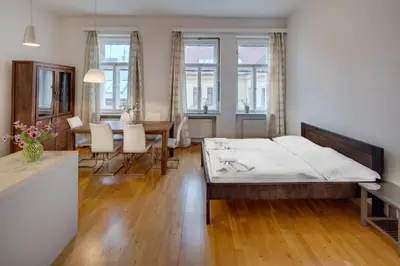 a bedroom with a bed and a dining room at Selinor Old Town Apartments in Prague