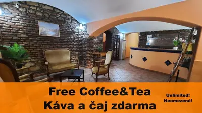a coffee shop with chairs and a stone wall at Pension City Center in Prague