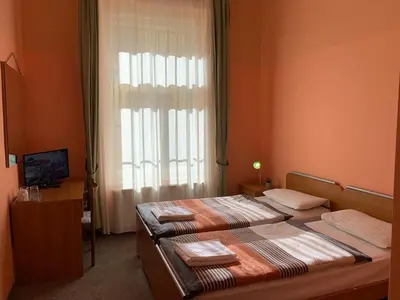 a bedroom with two beds in front of a window at Pension City Center in Prague