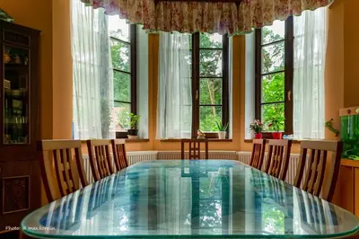 a dining room table with chairs and windows at Penzion Kersko in Hradišťko