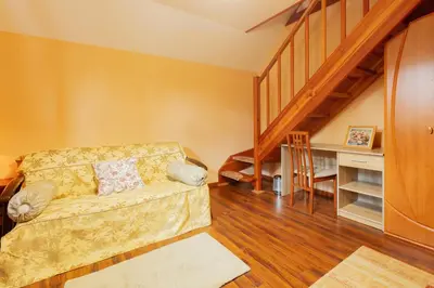 a living room with a couch and a staircase at Penzion Kersko in Hradišťko