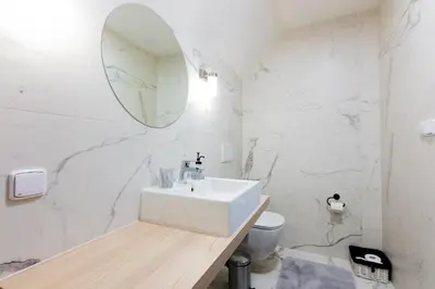 a white bathroom with a sink and a mirror at Penzion Kersko in Hradišťko