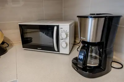 a coffee maker and a microwave on a counter at Spacious Terrace Apartment with free private parking in Prague