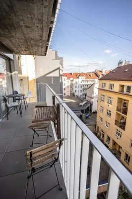 a balcony with benches and tables on a building at Spacious Terrace Apartment with free private parking in Prague