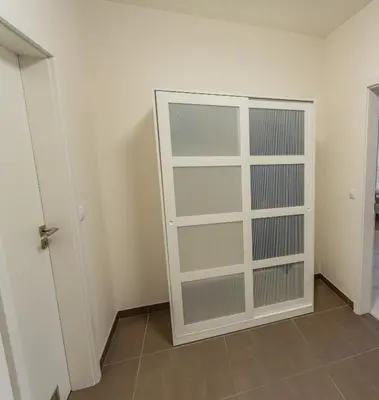 a closet with glass doors in a room at Spacious Terrace Apartment with free private parking in Prague