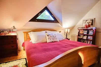 a bedroom with a large bed with a window at Rusty's Cottage in Sedlčany